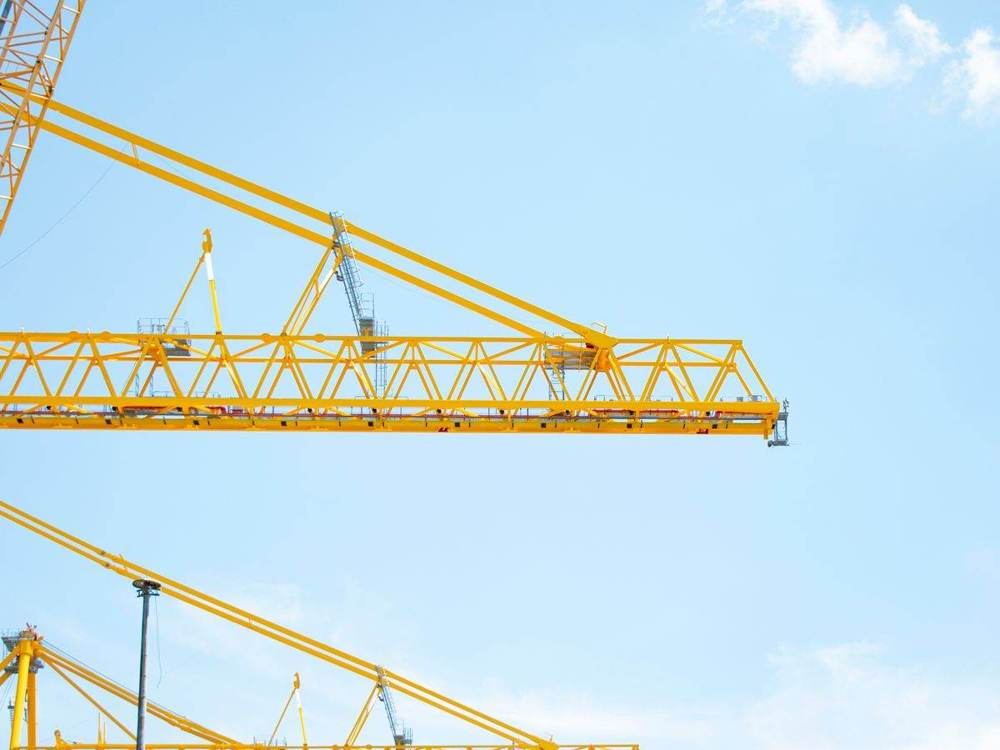 Construction cranes against a blue sky