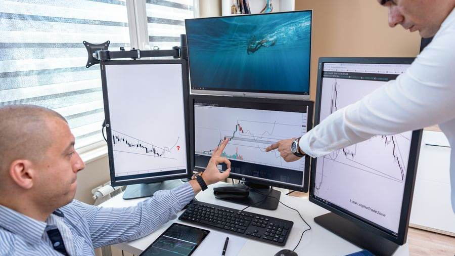Analysts at a multi-monitor workstation